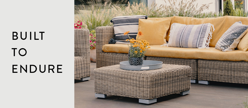 Resin Wicker Patio Sectional With Bright Orange Cushions Sitting in The Sun